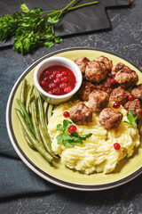 Swedish meatballs with mashed potatoes and green beans on stone background