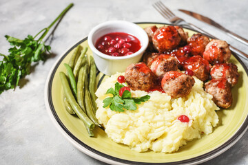 Swedish meatballs with mashed potatoes and green beans on concrete background