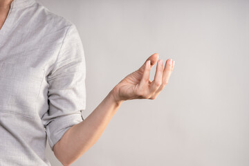 Naklejka premium Hold something with your hand while squeezing with your fingers. businesswoman in a casual gray shirt makes a hand gesture