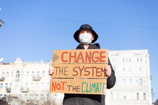 Solo picket protest in city square save the planet concept with slogan Change the System not the climate