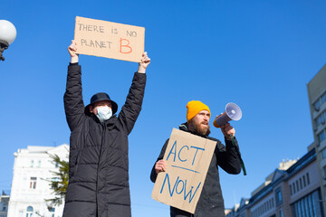 Two man protest in the city square for the concept of saving the planet Act now There is no planet...