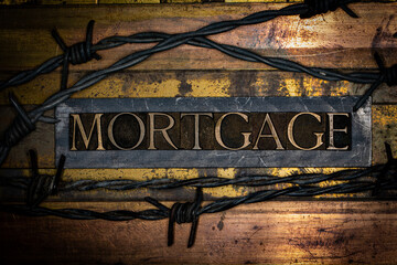 Mortgage text with barbed wire on lead bar lined with grunge textured coppered and bronze