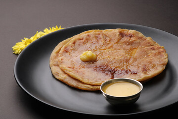 Puran Poli, also known as Holige, is an Indian sweet flatbread from India consumed mostly during Holi festival. Served in a plate with pure Ghee.
