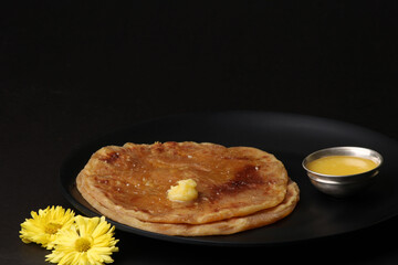 Puran Poli, also known as Holige, is an Indian sweet flatbread from India consumed mostly during Holi festival. Served in a plate with pure Ghee.