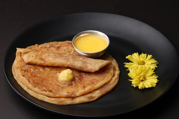Puran Poli, also known as Holige, is an Indian sweet flatbread from India consumed mostly during Holi festival. Served in a plate with pure Ghee.