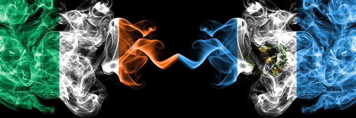 Republic of Ireland, Irish vs Guatemala smoky mystic flags placed side by side. Thick colored silky abstract smoke flags.