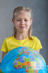A girl holds a globe in her hand