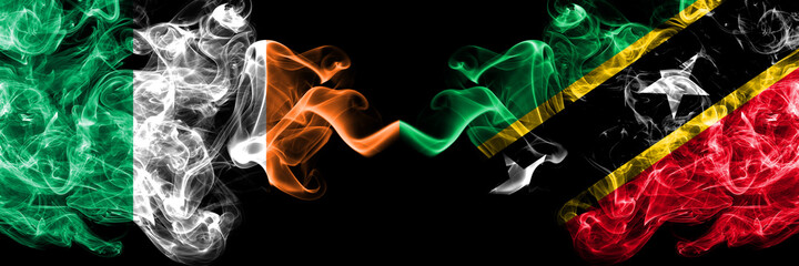 Republic of Ireland, Irish vs Saint Kitts and Nevis smoky mystic flags placed side by side. Thick colored silky abstract smoke flags.