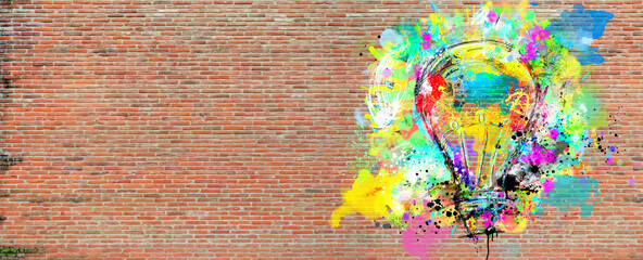 Big stylized light bulb on a big wall of bricks drawn with splashes of colored paint. Concept of innovation and creativity brick - obrazy, fototapety, plakaty
