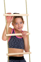 Girl performing gymnastic exercise on rope ladder.