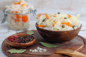 Homemade sauerkraut and fermented carrot in wooden bowl. with spices. Healthy probiotic food during winter.