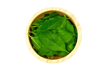 Tulsi or Holy basil leaf in wooden bowl isolated on white background top view. Tulsi is used in ayurvedic medicine.