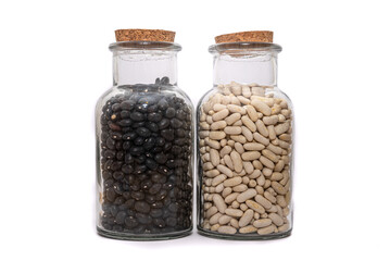 White Beans And Black Bean dried and preserved in glass jars isolated on a white background. Healthy nutritional preserved ingredients.