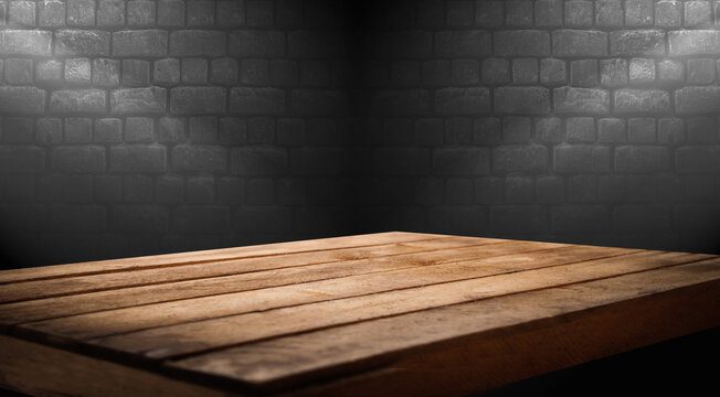 dark brick background in room with direct light and worn old wooden table