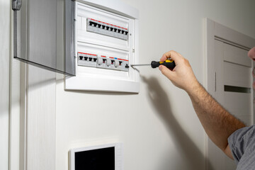 A closeup of an electrical engineer working in a power electrical panel in apartment building....