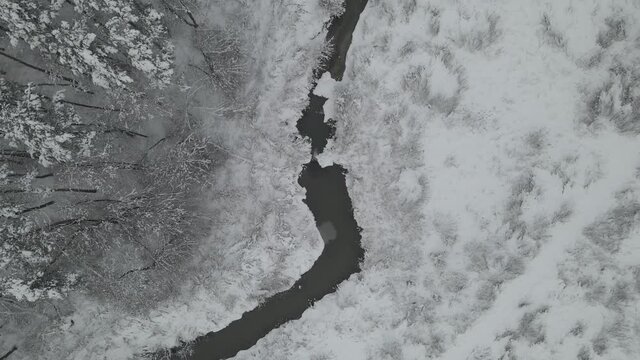 aerial view of winter landscape in the forest with a brook