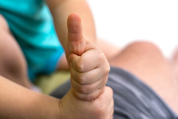 Kid hand making thumb up gesture Close-up of positive sign