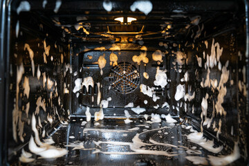 the oven is covered with cleaning foam. home cleaning concept