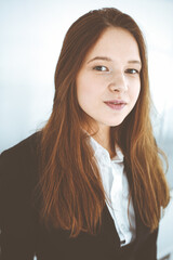 Business woman standing in white office. Student girl and success concept