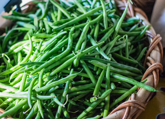 Vibrant organic green beans in a basket at farmers Market