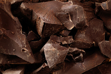 Chipped Dark Chocolate Pattern. Background of chocolate pieces. Food pattern.