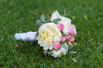 Wedding bouquet with rose flowers on green grass
