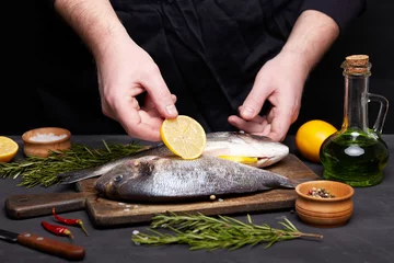 Foto op Canvas Process of cooking dorado fish with lemon and herbs. © Alexey