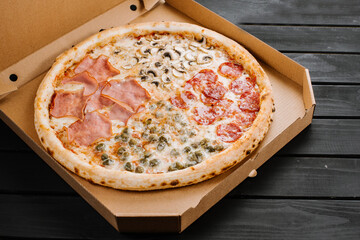 Tasty fresh pizza with four different pieces in one on wooden background