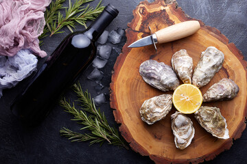 Fototapeta na wymiar Fresh closed oysters, ice and lemon on a round plate, stone textured background.