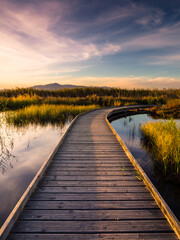 Fototapeta na wymiar Camino de agua se adentra en laguna con montaña al fondo y puesta de sol