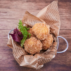 RACIÓN DE CROQUETAS CASERAS DE JAMÓN EN CUBITO BLANCO SOBRE FONDO DE MADERA