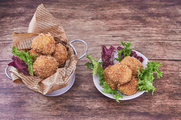 CROQUETAS  CASERAS DE JAM&Oacute;N PREPARADAS EN UN CUBITO BLANCO Y SOBRE UN FONDO DE MADERA