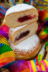 Pfannkuchen (Berliner) aufgeschnitten und übereinander, mit Puderzucker und Partydekoration
