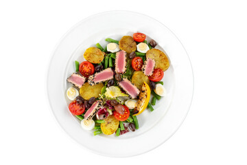 Nicoise salad, served on a white plate. Beautiful salad with tuna, egg, tomato and potatoes.