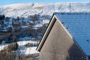 Fresh white snow cover on roof top of house and chimney,background white sky, beautiful winter...