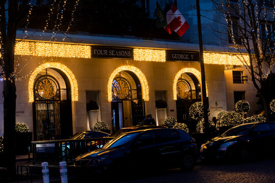 France, Paris - December 20 2020: George V Four Seasons Luxurious Hotel With Christmas Lights On Avenue George V At Dusk