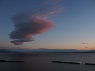 琵琶湖の上に浮かんだ朝焼けに染まったつるし雲
