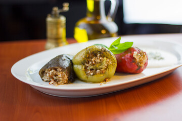 Stuffed bell pepper, red pepper and eggplant on a white plate