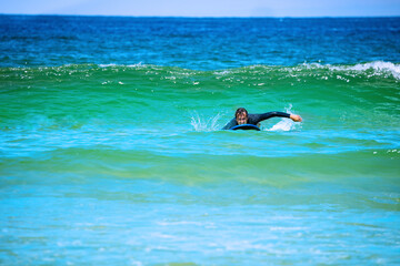 Portrait of the man paddling in the ocean to catch the wave view from water