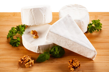 Camembert and brie cheese on cutting board on white background
