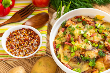 Potato casserole on a wooden background with vegetables. Top view.
