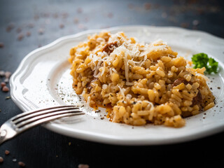 Risotto with chorizo and parmesan on wooden background
