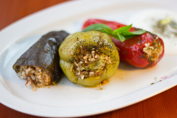 Stuffed bell pepper, red pepper and eggplant on a white plate