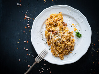 Risotto with chorizo and parmesan on wooden background
