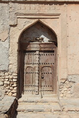 verschlossene Holztüre in Hauswand, Sultanat Oman