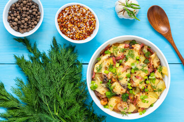 Cooked Tartiflette with bacon and herbs on a wooden blue background. Top view.