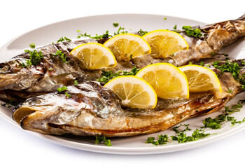 Fish dish - roasted trout with lemon on white background

