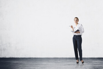 Smiling young businesswoman with planner in concrete room