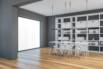 Grey and wooden room with chairs and bookshelf with books, parquet floor © ImageFlow