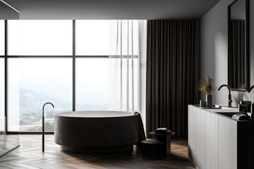 Obraz na płótnie Canvas Dark gray bathroom interior with round tub and sink, side view